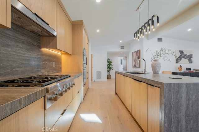 kitchen featuring decorative light fixtures, extractor fan, light brown cabinets, and sink