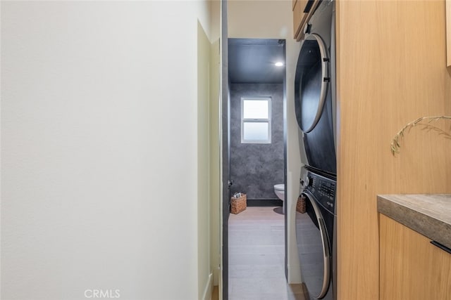 laundry room with stacked washing maching and dryer