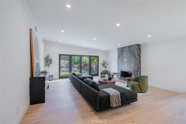 living room featuring a premium fireplace and light hardwood / wood-style floors