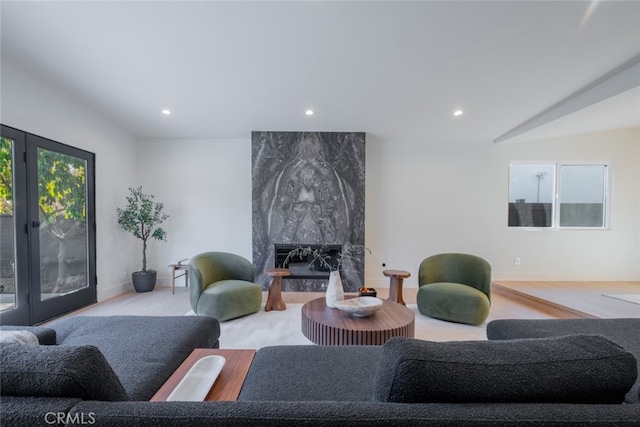 living room with vaulted ceiling, french doors, and a fireplace