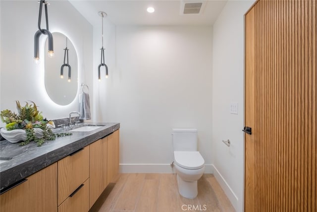 bathroom featuring hardwood / wood-style floors, toilet, and vanity