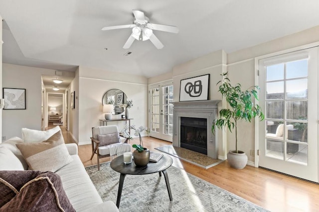 living room with ceiling fan, light wood-type flooring, and french doors