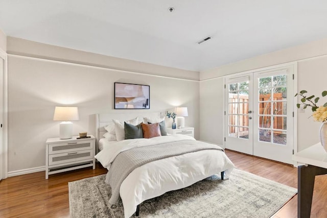 bedroom with wood-type flooring, access to exterior, and french doors