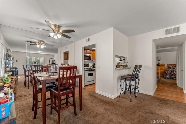 dining area with ceiling fan and carpet flooring