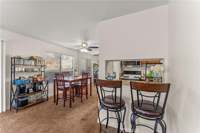 carpeted dining room featuring ceiling fan