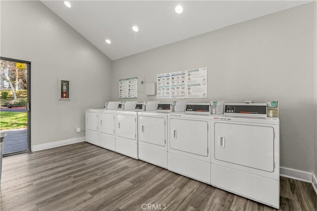 laundry room featuring separate washer and dryer, dark hardwood / wood-style flooring, and a towering ceiling