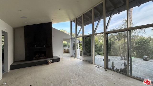 unfurnished living room featuring a high ceiling and a large fireplace