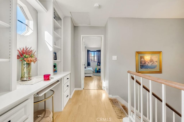 hall featuring built in features and light hardwood / wood-style floors