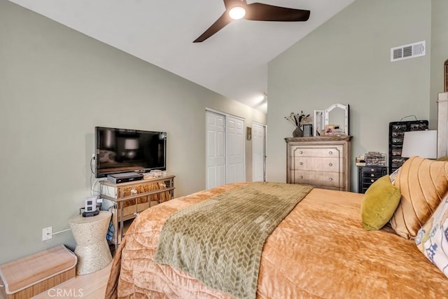 bedroom with ceiling fan, multiple closets, and vaulted ceiling