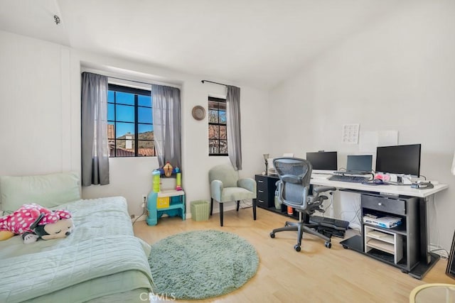 bedroom with lofted ceiling and light hardwood / wood-style flooring