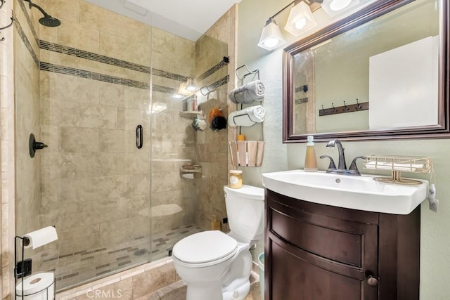 bathroom featuring toilet, a shower with door, and vanity