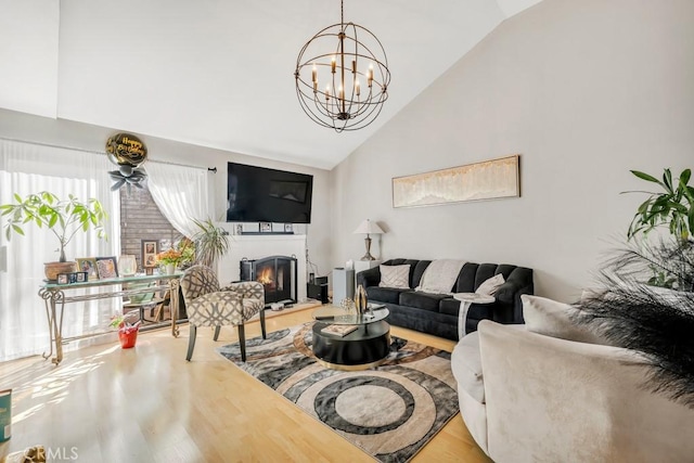 living room featuring vaulted ceiling, an inviting chandelier, and hardwood / wood-style flooring