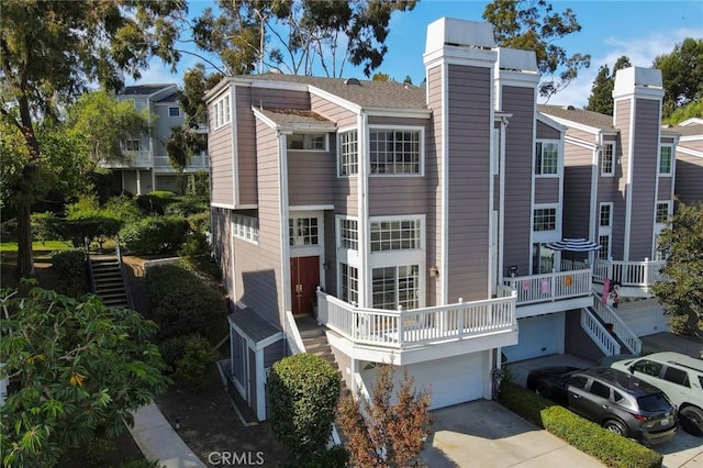 rear view of property featuring a garage and a balcony