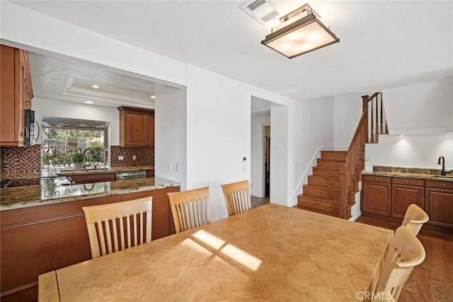 dining room with sink and a tray ceiling