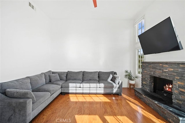 living room featuring hardwood / wood-style floors and a stone fireplace