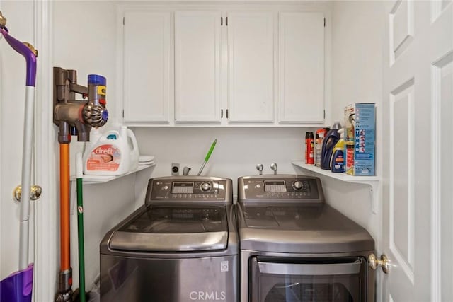 clothes washing area with cabinets and washing machine and clothes dryer