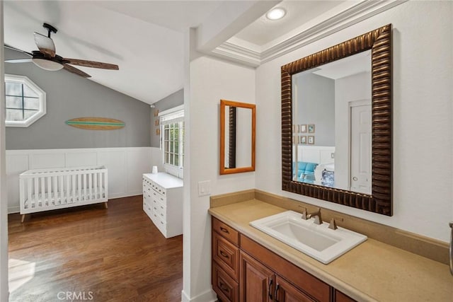 bathroom featuring ceiling fan, vanity, lofted ceiling, hardwood / wood-style flooring, and radiator