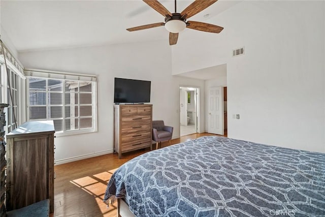 bedroom featuring vaulted ceiling, ceiling fan, hardwood / wood-style flooring, and ensuite bath