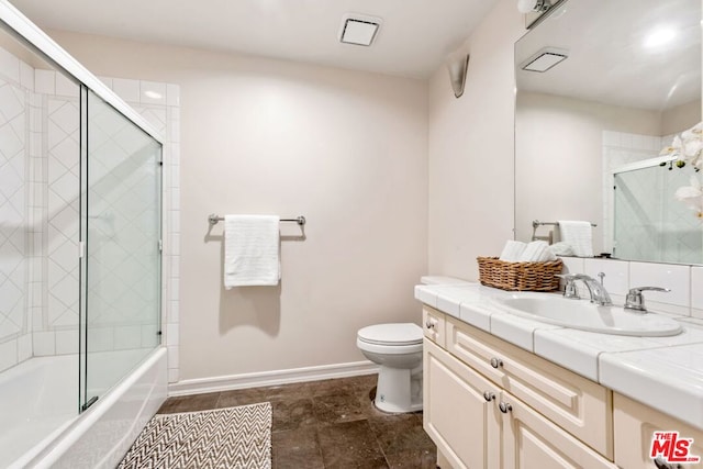 full bathroom featuring enclosed tub / shower combo, vanity, and toilet