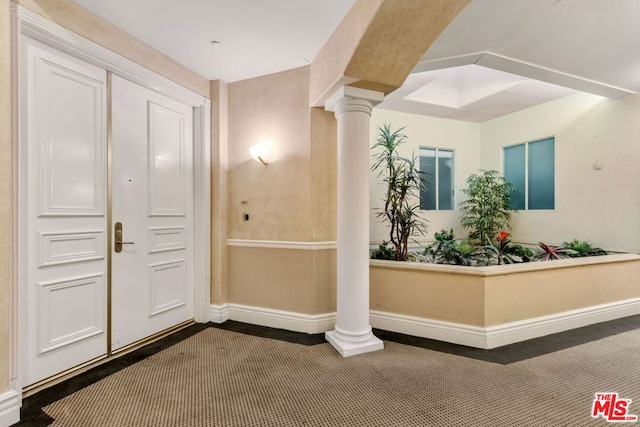 interior space featuring dark carpet and decorative columns