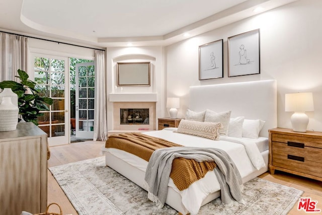 bedroom with access to exterior and light hardwood / wood-style floors