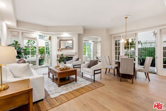 living room featuring light wood-type flooring and an inviting chandelier