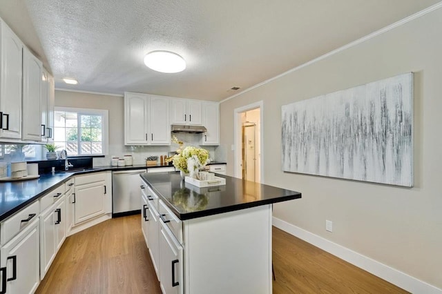 kitchen with white cabinetry, a kitchen island, sink, and stainless steel dishwasher