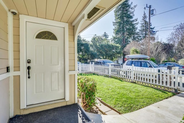 view of exterior entry with a yard