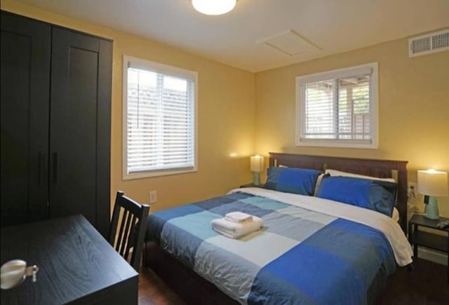 bedroom with dark hardwood / wood-style floors