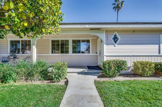 doorway to property featuring a lawn