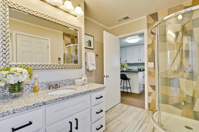 bathroom featuring an enclosed shower, vanity, and crown molding