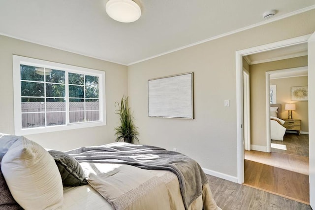 bedroom featuring ornamental molding and hardwood / wood-style floors