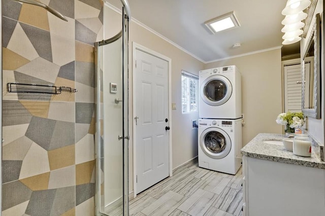 clothes washing area with ornamental molding and stacked washer / dryer