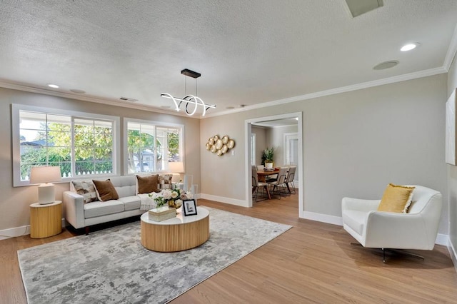 living room with crown molding, a textured ceiling, and light wood-type flooring