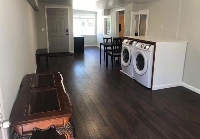 clothes washing area with separate washer and dryer and dark hardwood / wood-style flooring