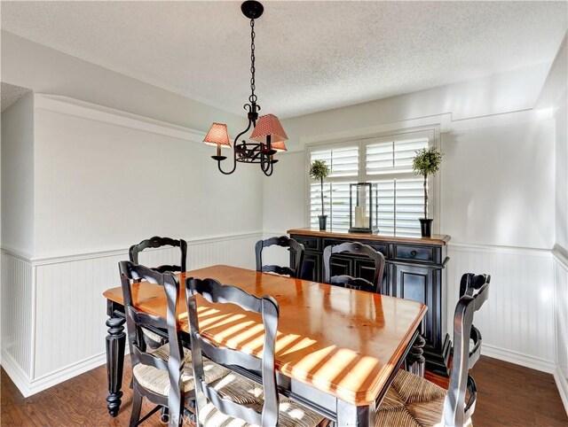 dining room featuring dark wood-type flooring and a textured ceiling