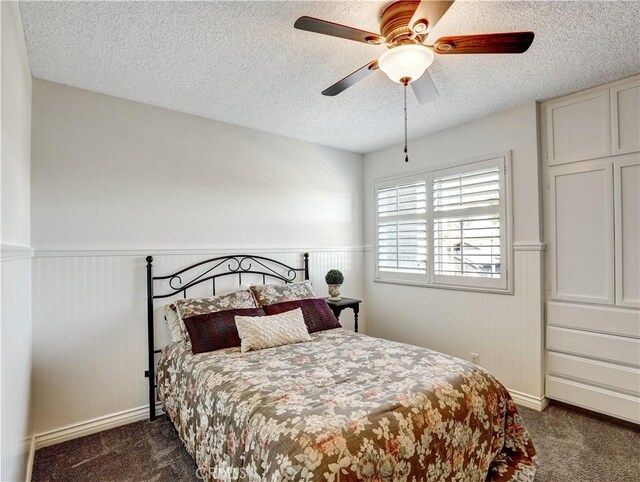 carpeted bedroom with ceiling fan and a textured ceiling