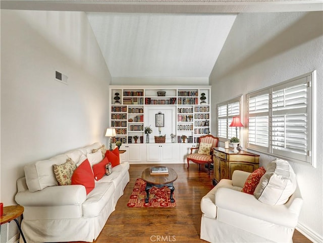 living area with visible vents, vaulted ceiling, baseboards, and wood finished floors