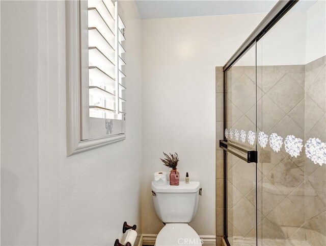 bathroom with an enclosed shower and toilet