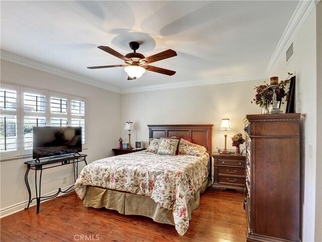 bedroom with dark wood-type flooring, ceiling fan, and crown molding