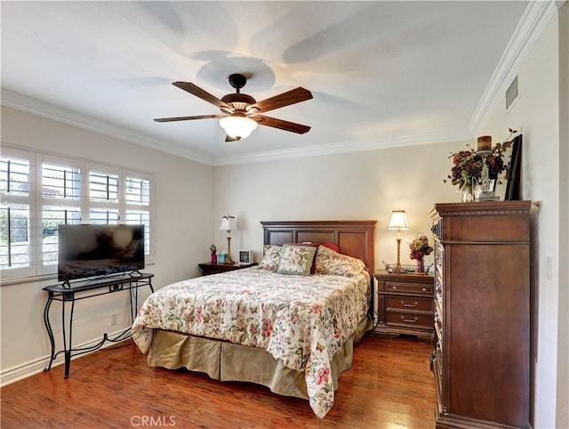 bedroom with crown molding, visible vents, and wood finished floors