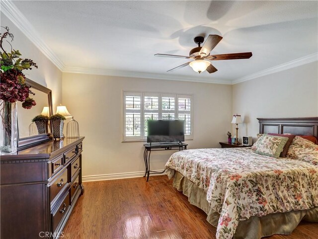 bedroom with ceiling fan, dark hardwood / wood-style flooring, and crown molding