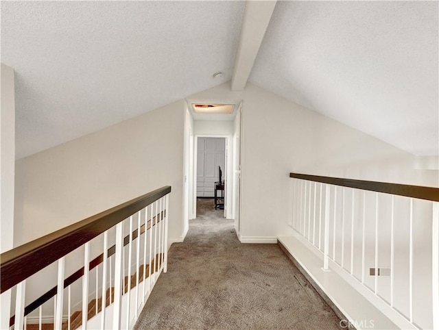 hall featuring carpet floors, an upstairs landing, lofted ceiling with beams, and baseboards