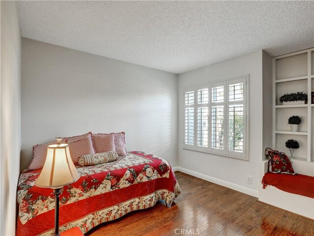 bedroom featuring dark wood-type flooring and a textured ceiling