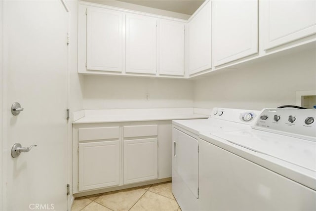 laundry room with separate washer and dryer, cabinets, and light tile patterned flooring