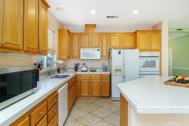 kitchen with light tile patterned flooring, tile countertops, sink, a center island, and white appliances