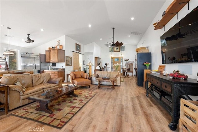 living room featuring high vaulted ceiling, light hardwood / wood-style floors, and ceiling fan