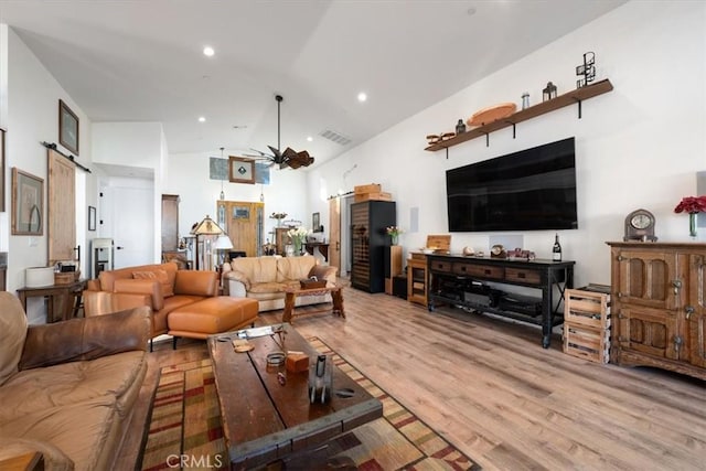 living room featuring light hardwood / wood-style flooring and high vaulted ceiling