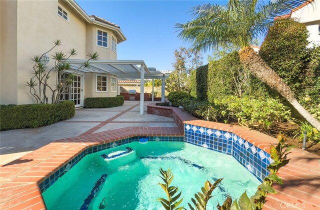 view of pool with a patio and a hot tub