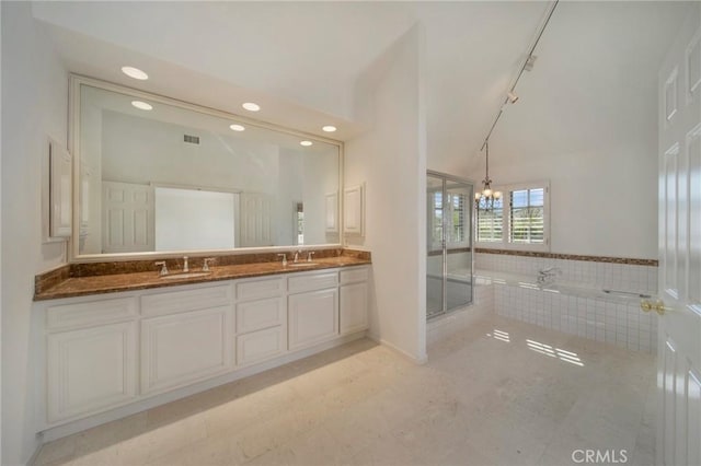 full bath featuring visible vents, a garden tub, double vanity, a stall shower, and a sink